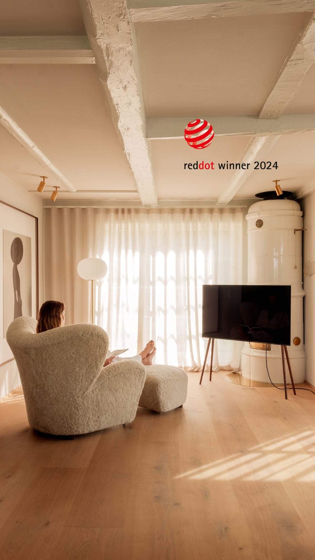 Freestanding JALG TV stand in a modern living room with a big light armchair, Red Dot Winner 2024, mobile layout