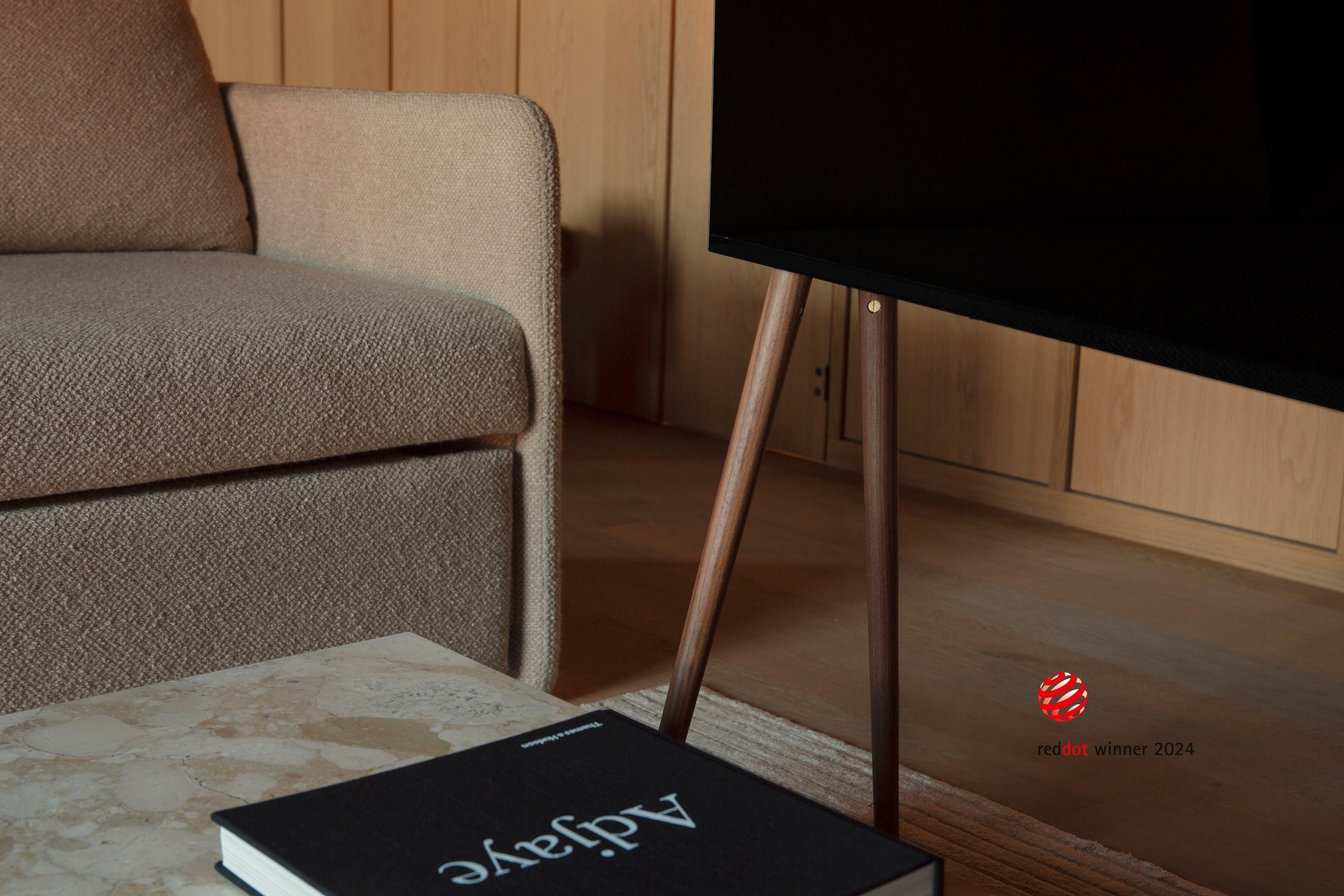 A close-up view of freestanding JALG TV stand, Red Dot Winner 2924, desktop layout