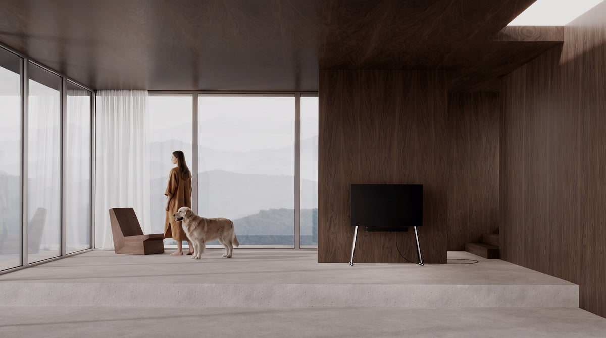 JALG TV Stands stainless steel collection, minimalist TV stand on wheels in a modern room against a dark wood-panelled wall